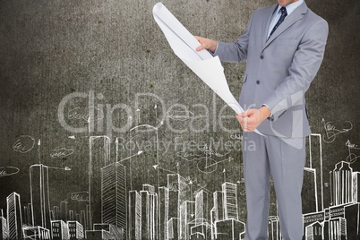 Architects holding plan against cityscape background