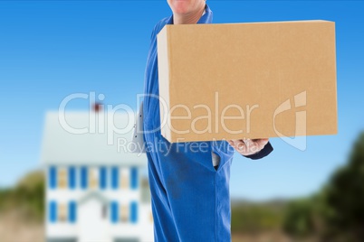 Deliver wearing a overall is holding a package against house background