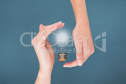 Light bulb between two hands with blue background