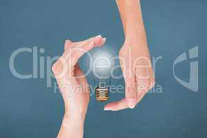 Light bulb between two hands with blue background