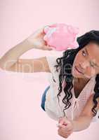 Broke black woman looking on piggy-bank . empty pocket concept.Pink background