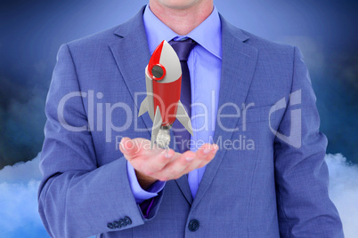 Businessman holding a rocket toy in his hands