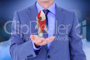 Businessman holding a rocket toy in his hands