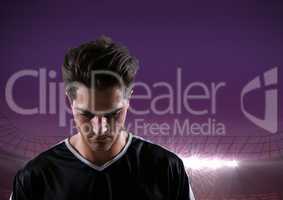 soccer player looking down, purple field lights background