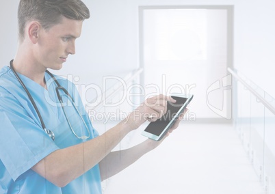 Doctor holding tablet in bright modern corridor