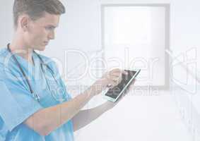 Doctor holding tablet in bright modern corridor