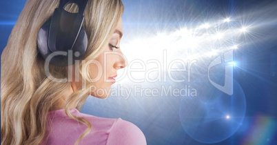 Blond-hair girl listenning music with headphones back to the photo with blue background