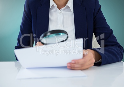 Model with magnifying glass looking at papers