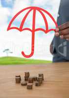 Cut out umbrella protective over money coins and landscape
