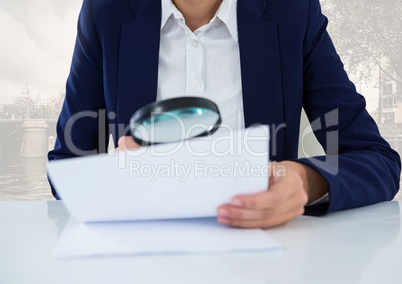 Holding magnifying glass over papers