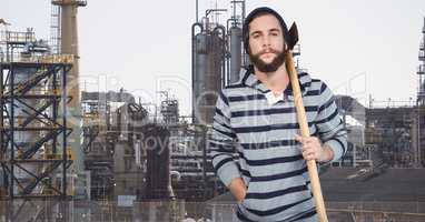 Hipster holding axe while standing against factory