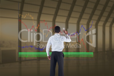 Business man drawing graphics on the screen from the back against indoor background