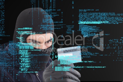 Cyber criminal wearing a hood is holding a credit card against matrix digital rain background