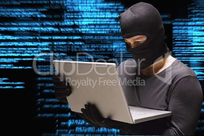 Cyber criminal is hacking from a laptop against matrix code rain background