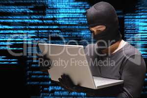 Cyber criminal is hacking from a laptop against matrix code rain background