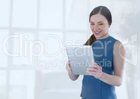 Businesswoman holding tablet in office by bright window