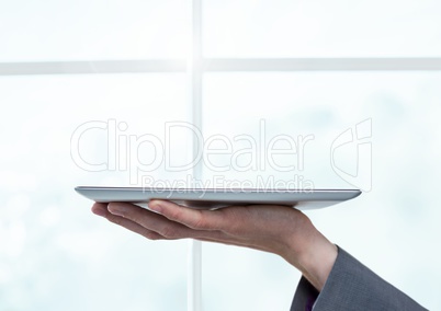Businesswoman holding tablet by bright window