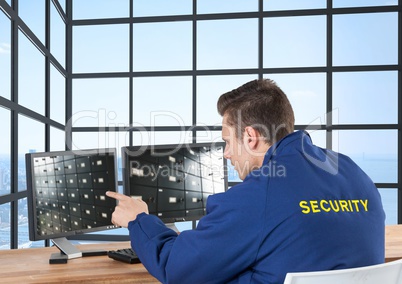 security guard looking the image of the security camera ion the screens in his office