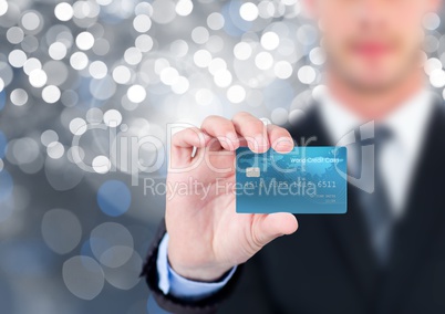 Hand holding credit bank card with sparkling light bokeh background