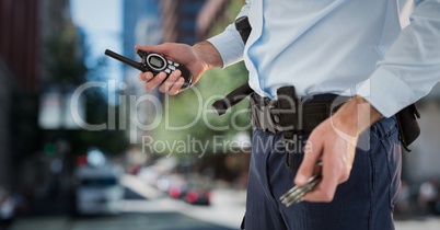 Security guard lower body with walkie talkie against blurry street