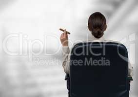 Back of seated business woman smoking cigar against blurry grey stairs