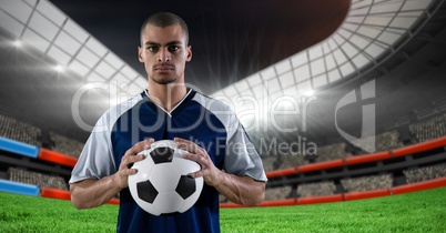 Football player holding a football in a stadium