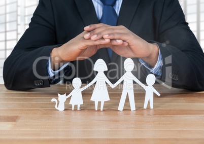 Cut outs of family under protective hands