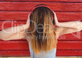 hipster woman listening music with red wood background