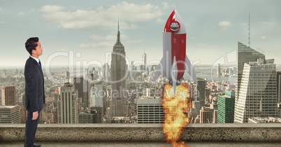 Digital composite image of businessman looking at  rocket launch in city