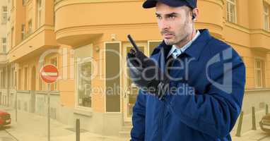 Security guard holding walkie talkie while standing on road against buildings