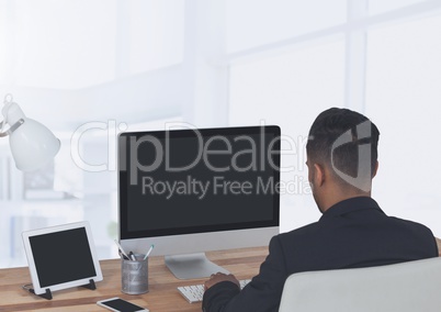 Businessman on computer in large bright office