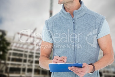 Technician is writing a report against building under construction background