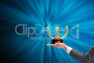 Hands of businessman holding a trophy in a blue background