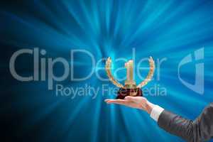 Hands of businessman holding a trophy in a blue background