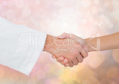 Hands shaking with sparkling light bokeh background