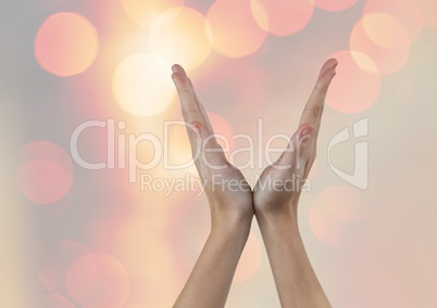 Hands in V Shape with sparkling light bokeh background