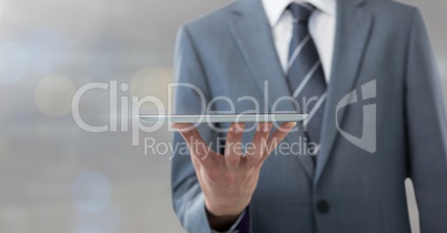 Businessman holding tablet with grey background