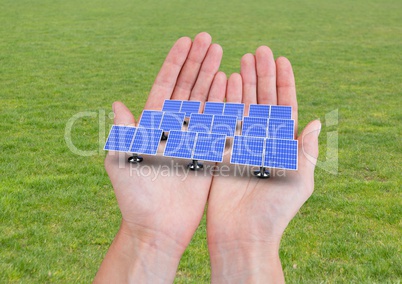 solar panels on hands. grass back