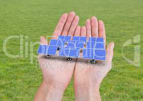 solar panels on hands. grass back