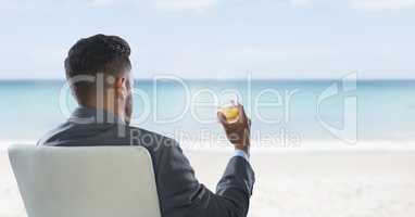Businessman Back Sitting in Chair with drink glass and sea