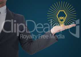 Business man mid section with yellow lightbulb graphic in hand against blue background