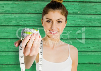 fitness woman apple and meter with green wood background
