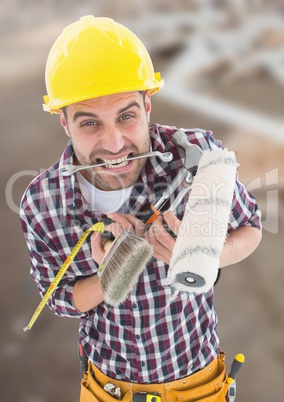 Construction Worker with paint tools in front of construction site