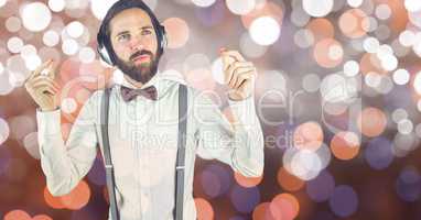 Hipster man listenning music with headphones in front of colored background