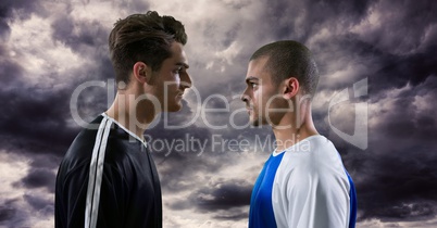 Two football players watching each other under dark clouds