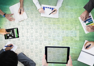 Overhead of business team with green wood panel and lightbulb doodles