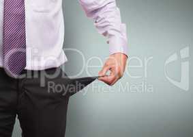 Midsection of businessman showing empty pocket standing against green background