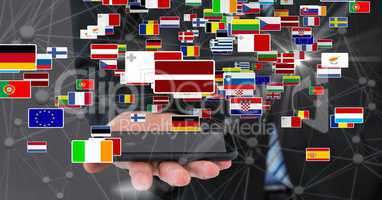Businessman holding smart phone with various flags and connecting dots