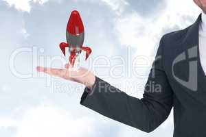 Business man holding a rocket against the sky
