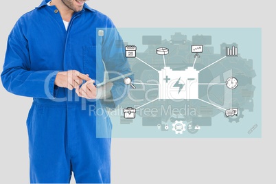 worker wearing overall is writing a report on a tablet computer against grey background